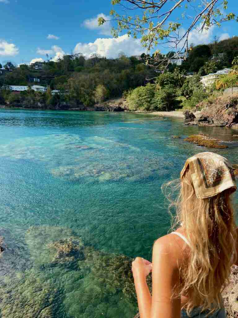 a woman at a a small cove with crystal clear sea at meadows battery castries st lucia