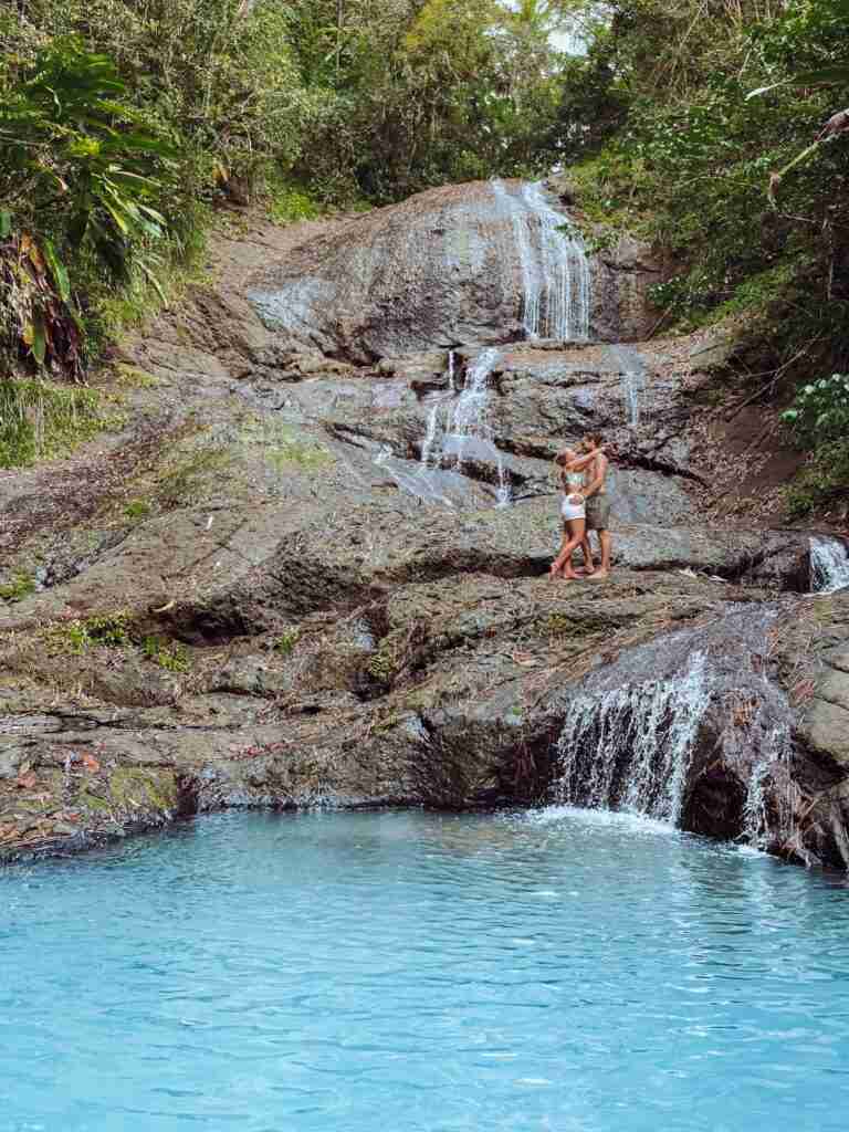 couple on a waterfall showing the best part of Saint Lucia to stay