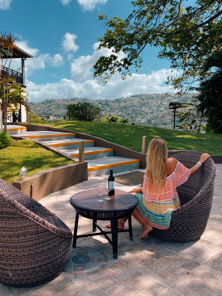 a woman drinking wine at a hotel highlighting the best area to stay in st lucia