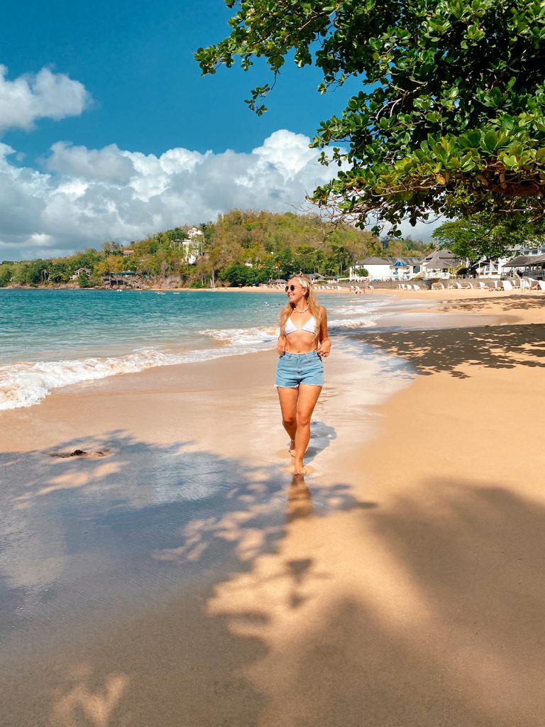 a woman walking on a white sand beach