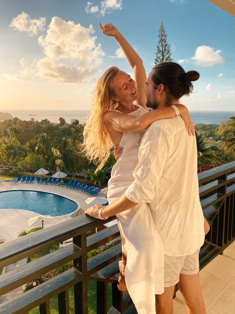 a couple on a balcony at bel jou hotel in castries highlighting the best area to stay in st lucia